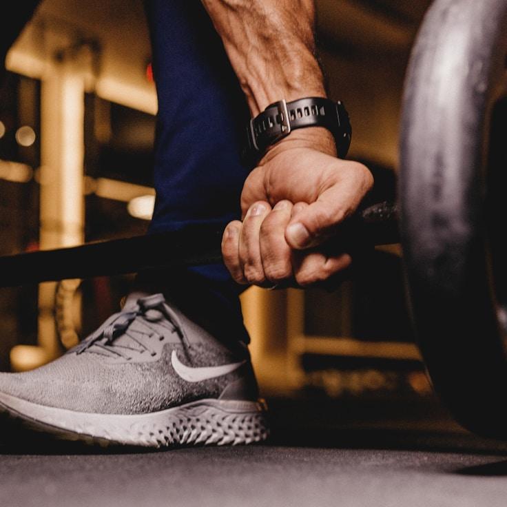 Interior view of a well-equipped gym with mirrors and weight training gear